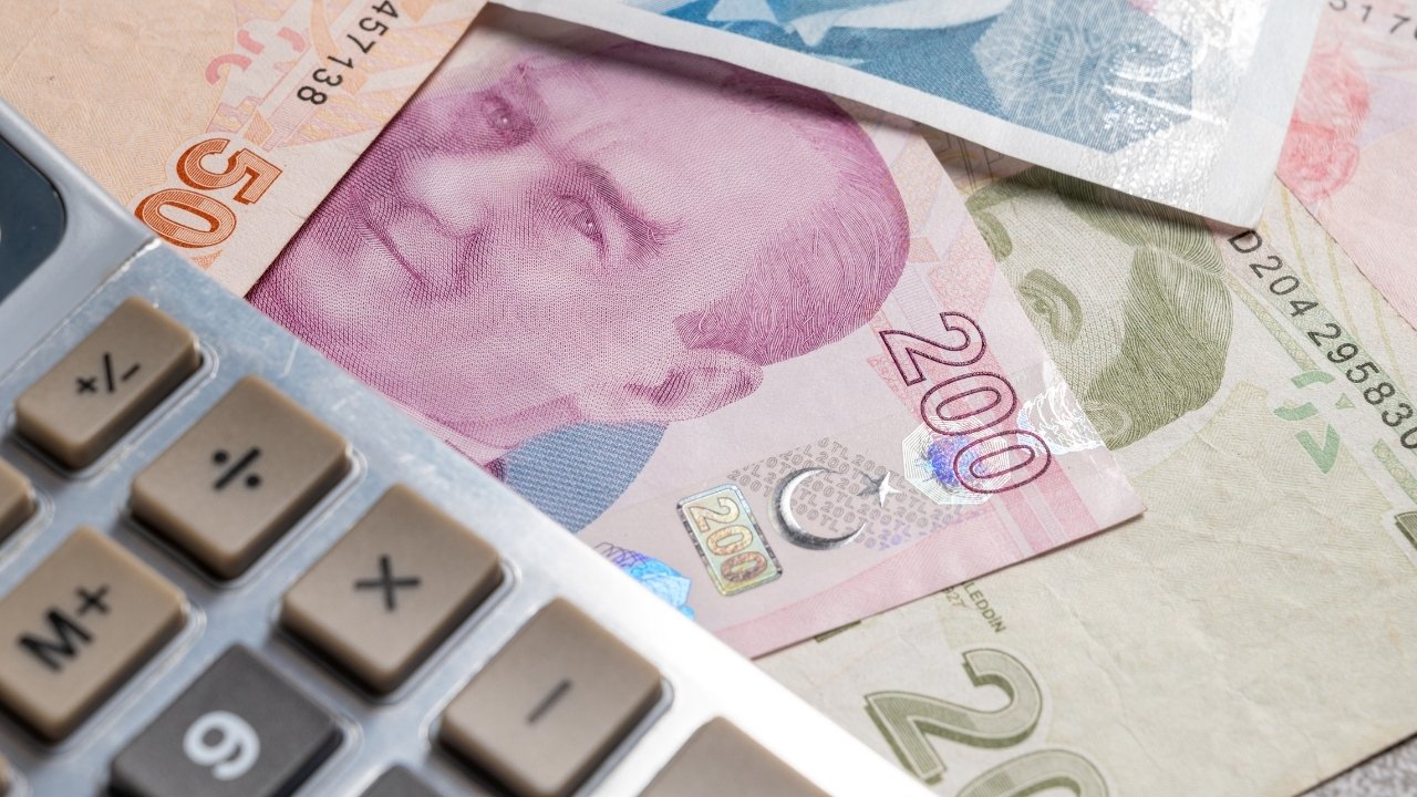 Close-up view of a calculator and Turkish lira banknotes.