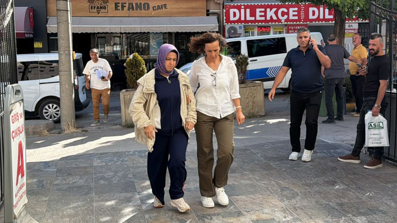 Bir kişinin adliye çevresinde görevliler eşliğinde yürüdüğü fotoğraf.