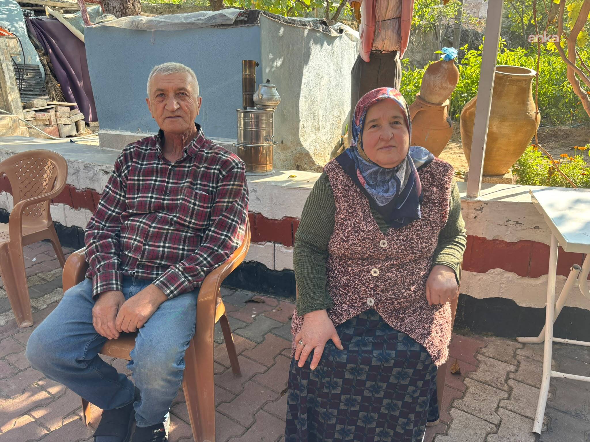 Relatives of Nevzat İnan, who lives in the village of Yaprakhisar, sit side by side in a house courtyard.