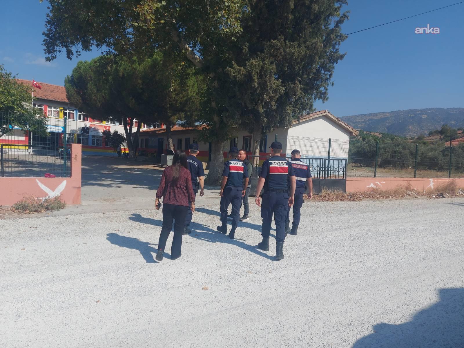 Jandarma personelinin bir okul girişine doğru yürüdüğü denetim görüntüsü.