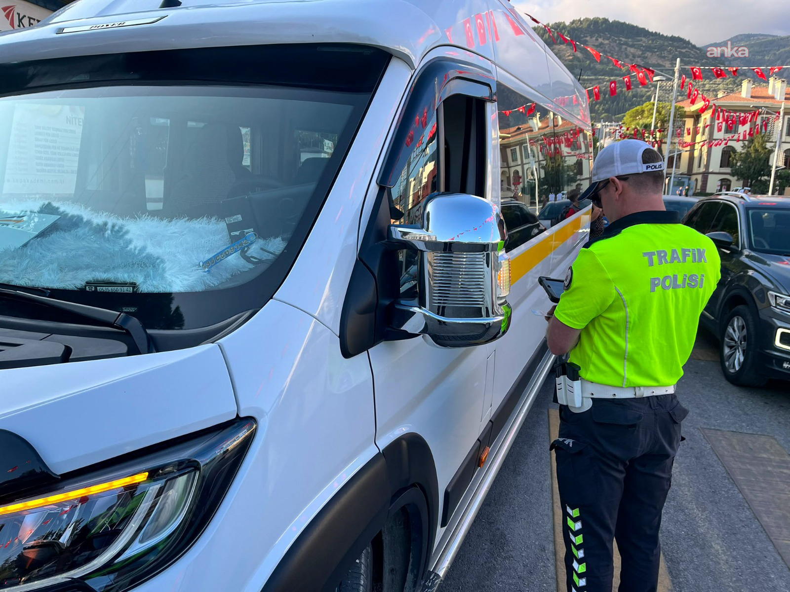 Trafik polisinin okul servisi yanında kontrol yaptığı görüntü.