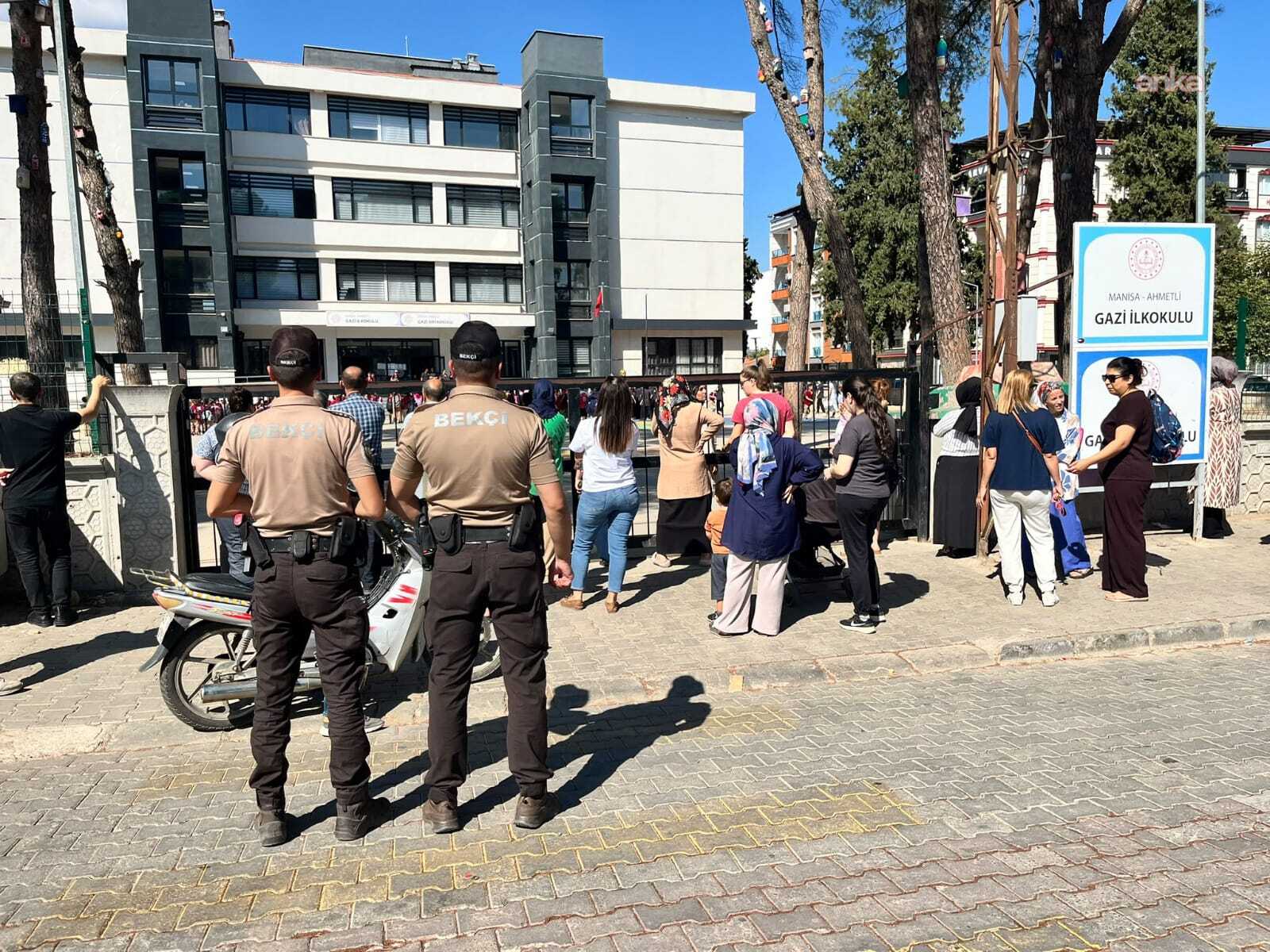 Okul girişinde bekçi ekipleri ve velilerin bulunduğu denetim görüntüsü.