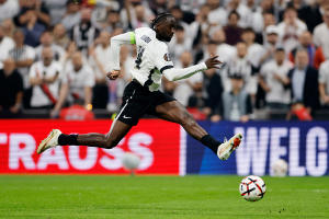 Beşiktaş forması giyen bir futbolcu maç sırasında topa müdahale ediyor.