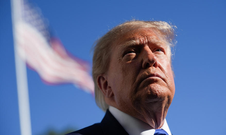 Donald Trump, arka planda Amerikan bayrağıyla yakından görüntüleniyor.