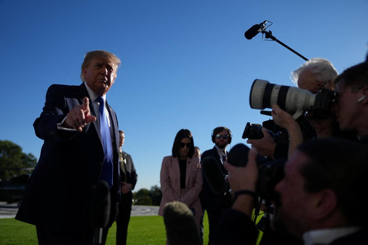 Donald Trump açık havada gazetecilerin ve kameraların karşısında konuşurken görülüyor.