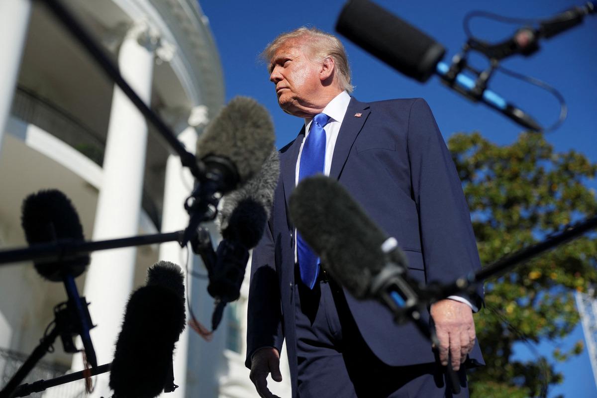 Donald Trump, Beyaz Saray yakınında mikrofonların önünde dururken görülüyor.
