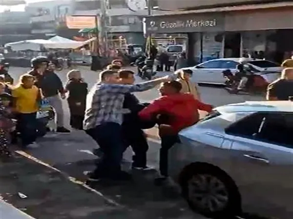 Bir iş yerinin önünde yaşanan silahlı saldırı anını gösteren güvenlik kamerası görüntüsü.