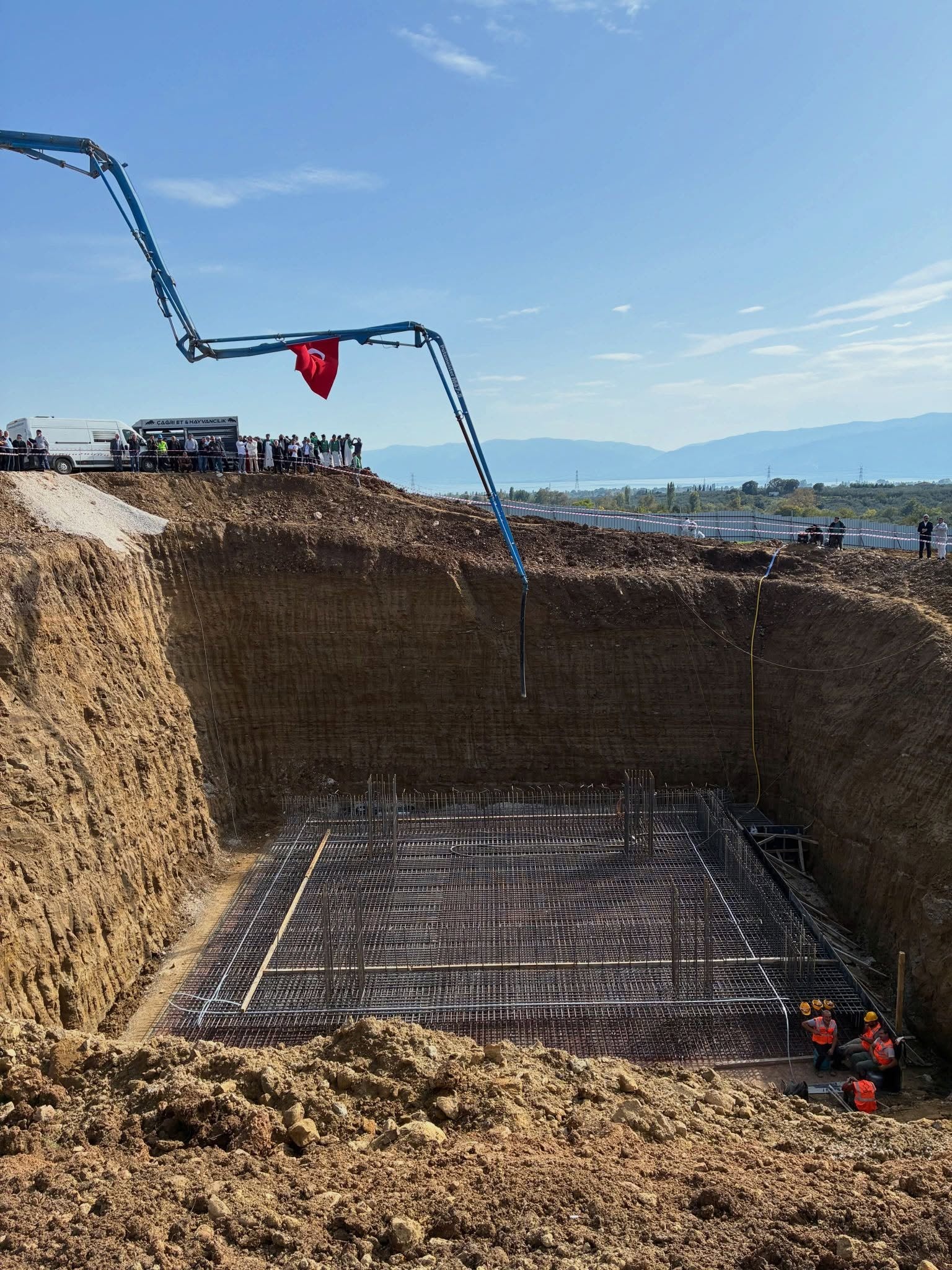 Bursa Orhangazi’deki inşaat alanında derin kazı, beton pompası ve temel demirleri görülüyor.