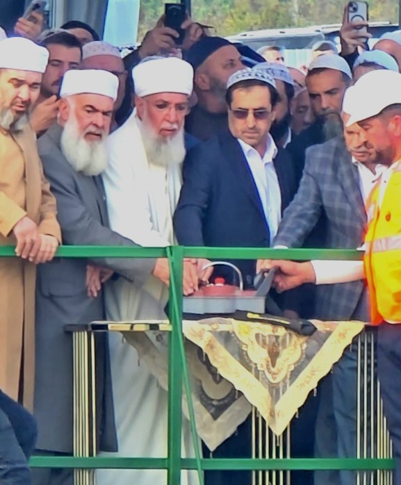 Tören alanında bir platform üzerinde, temel atma anında bir araya gelen katılımcılar görülüyor.