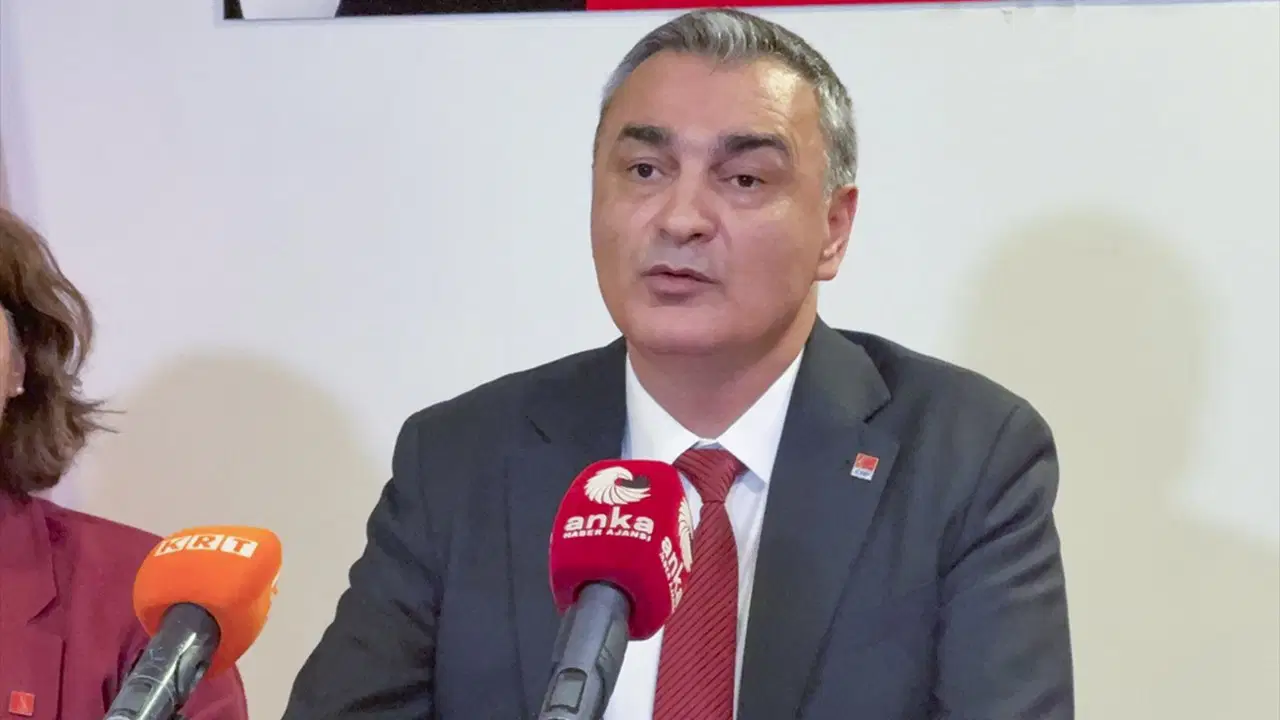 Müslim Sarı, mikrofonların önünde açıklama yaparken görülüyor.