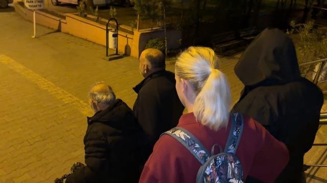 Polis eşliğinde merdivenlerden indirilen şüphelilerin gece çekilmiş görüntüsü.