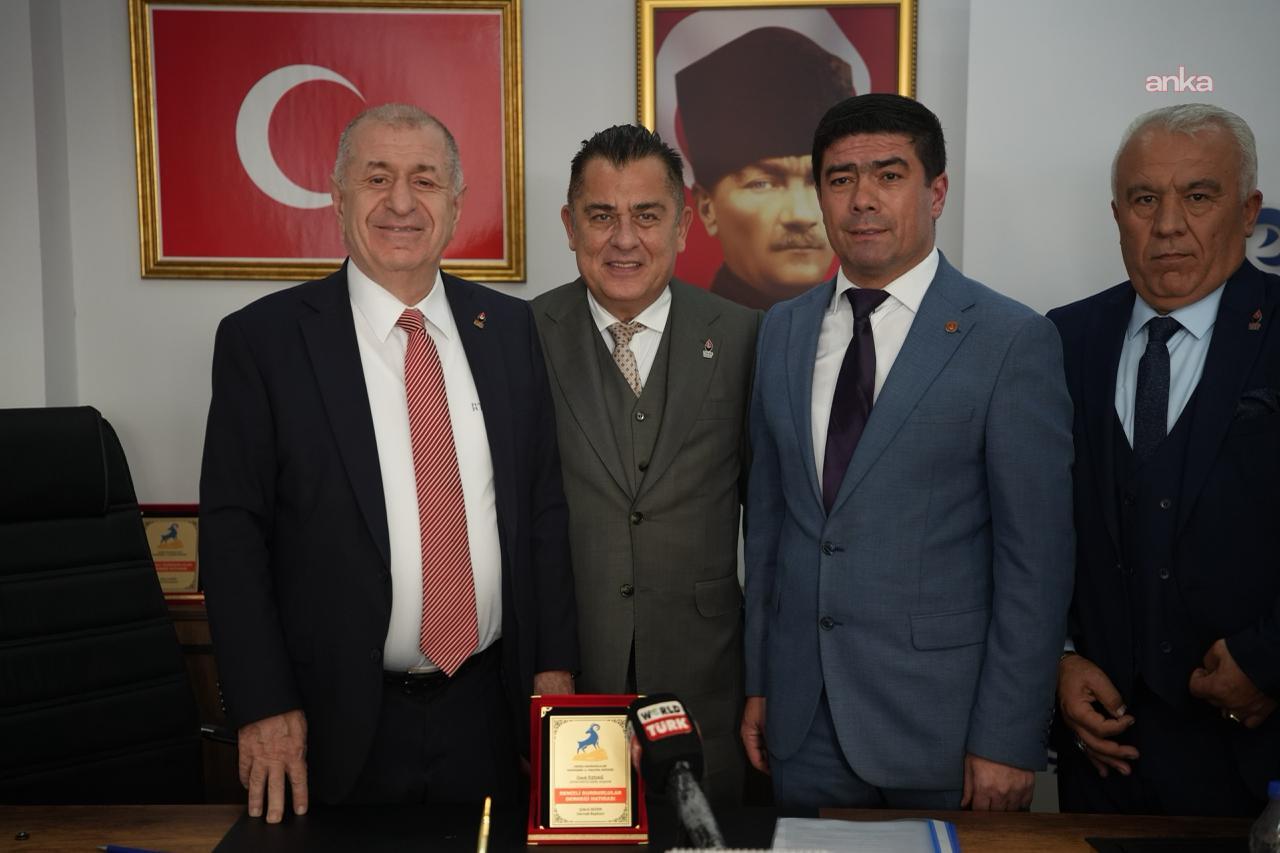 Ümit Özdağ ve beraberindeki kişilerin Türk bayrağı ve Atatürk portresi önünde toplu fotoğrafı.