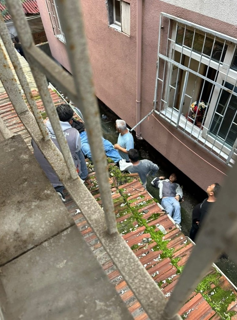 Apartmanın iç avlusunda yaralıların bulunduğu bölge ve olay yerine gelen kişiler.