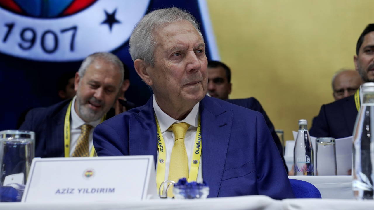 Aziz Yıldırım, Fenerbahçe logosunun yer aldığı salonda toplantı masasında oturuyor.