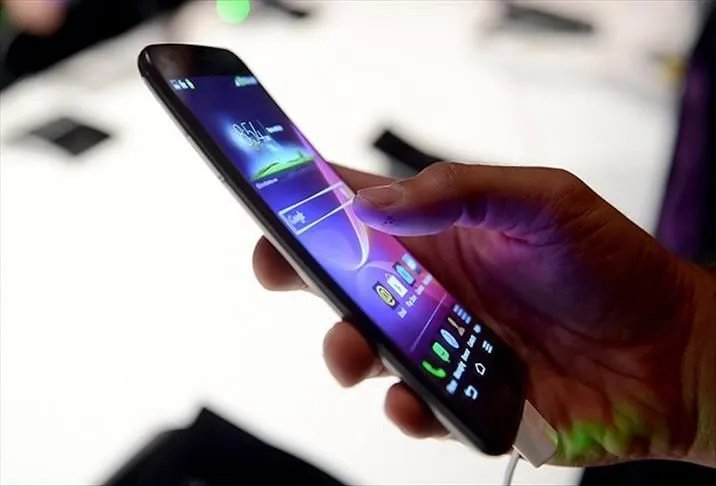 Bir kişinin elinde tuttuğu akıllı telefon ekranına dokunduğu yakın plan görüntü.