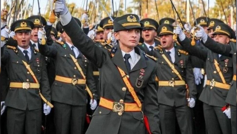 Image of the lieutenants raising their swords at the Military Academy graduation ceremony.