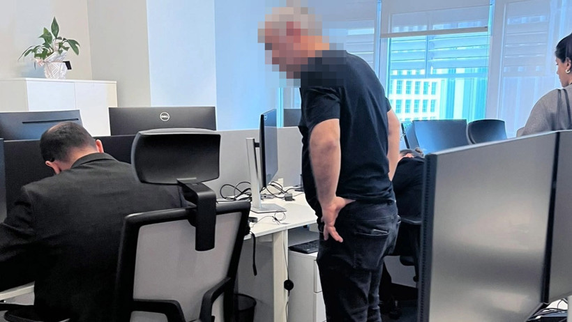 Bir ofiste bilgisayar masaları ve koltukların bulunduğu alanda mal tespiti yapıldığı görülen kare.