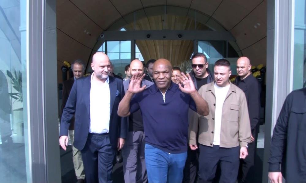 Mike Tyson, İstanbul Havalimanı özel terminali çıkışında beraberindekilerle yürürken basını selamlıyor.