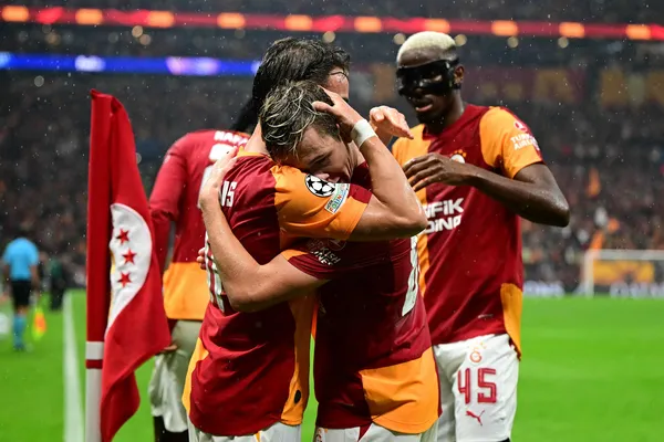 Galatasaraylı futbolcuların saha kenarında sevinç yaşadığı maç fotoğrafı.