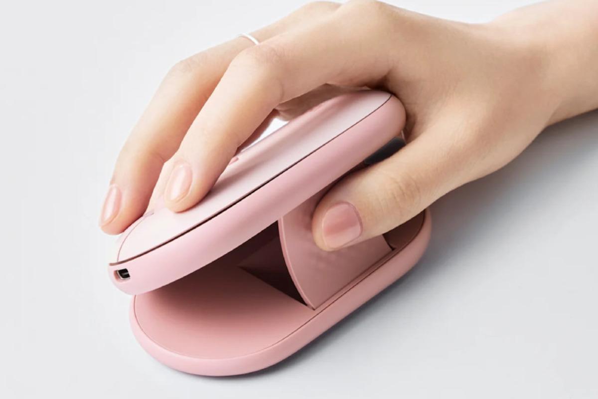 Close-up image showing a pink Logitech Pebble Up mouse being used in an ergonomic position in the hand.
