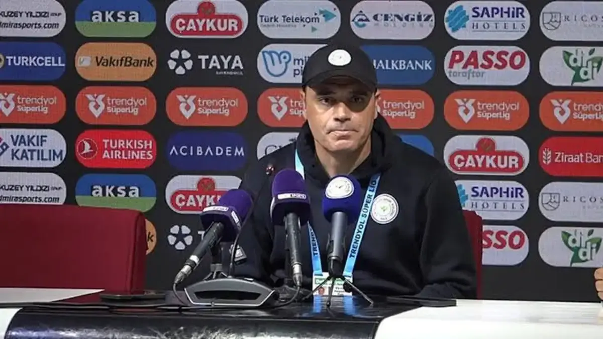 Çaykur Rizespor Yardımcı Antrenörü Ekrem Dağ basın toplantısında mikrofonların önünde konuşuyor.