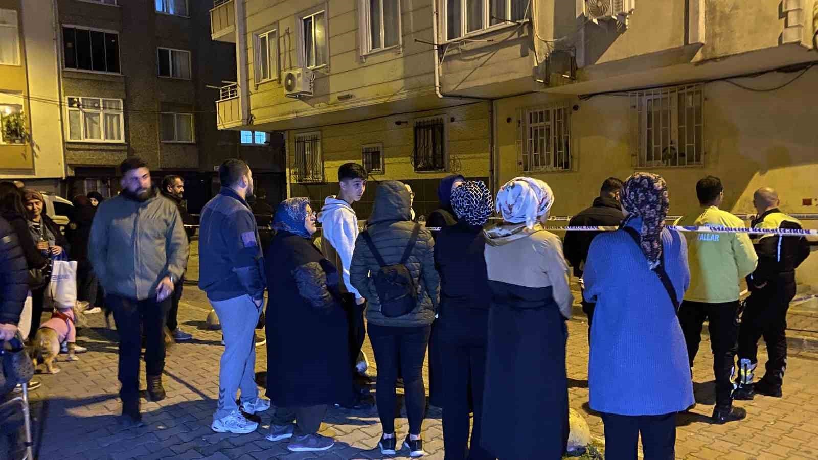 Güvenlik şeridinin arkasında bekleyen bina sakinleri ve görevliler.
