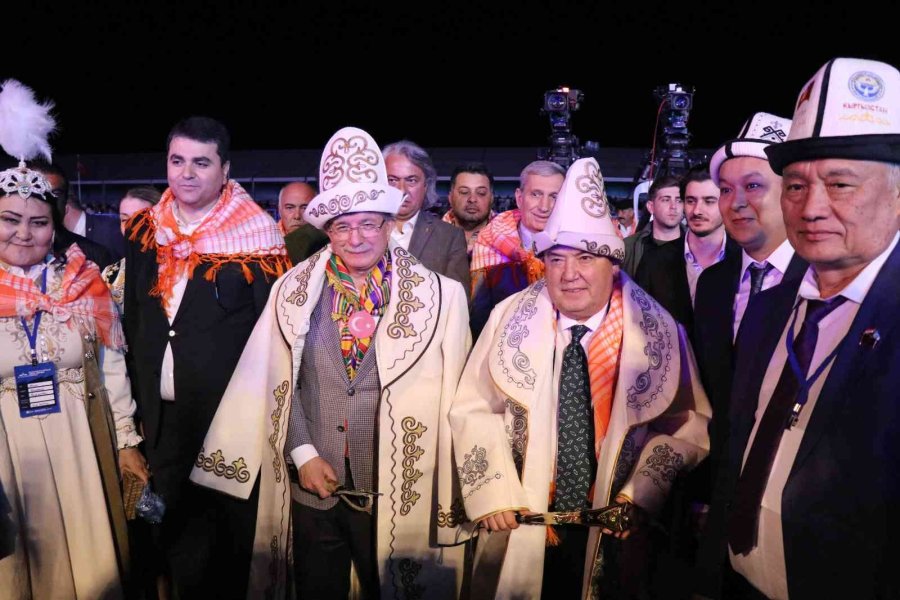 Participants in local attire and guests are seen at a festival event held at night.