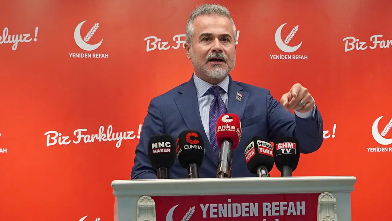 Suat Kılıç, Yeniden Refah Partisi arka planı önünde basın toplantısında konuşuyor.