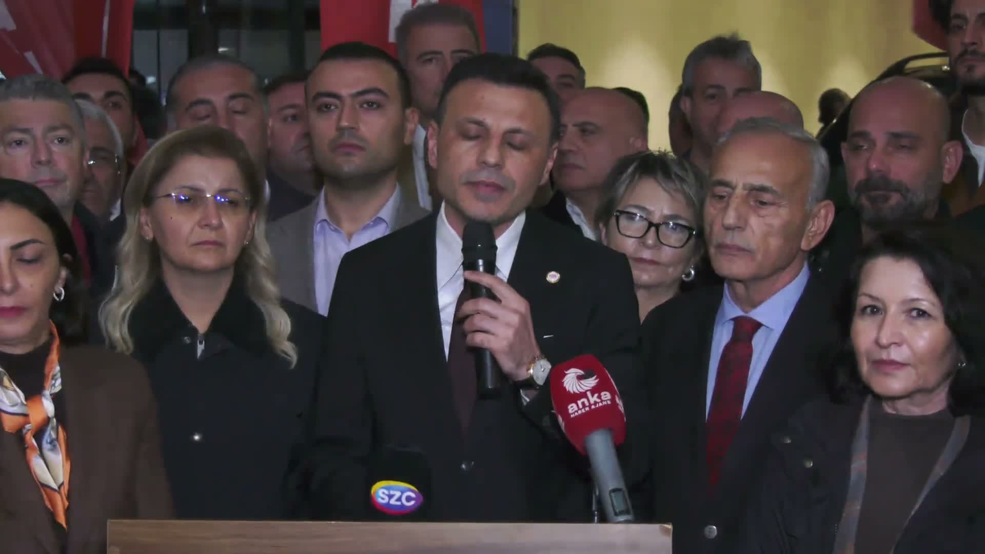 Özgür Çelik spricht vor einer Menschenmenge in ein Mikrofon, ein ANKA-Mikrofon ist zu sehen.
