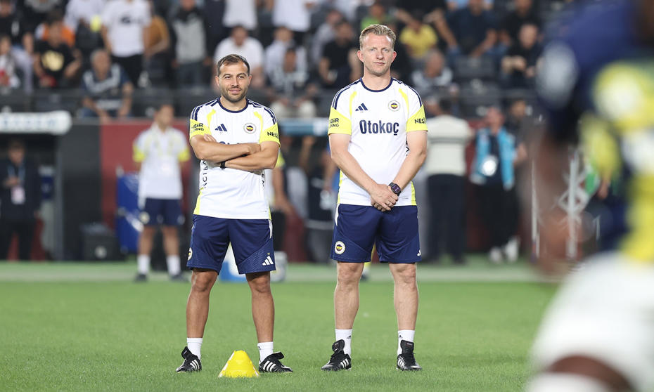 Dirk Kuyt ve Fenerbahçe teknik ekibinden bir isim saha kenarında antrenman kıyafetleriyle görülüyor.