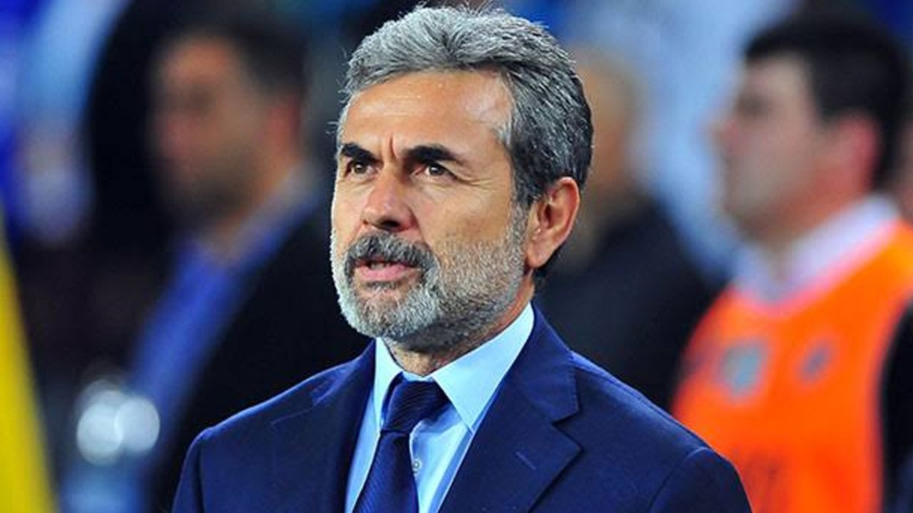 Aykut Kocaman saha kenarında takım elbiseyle görülüyor.