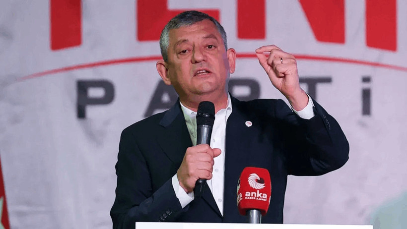YENİ Parti-Vorsitzender Özgür Özel bei einer Rede vor dem Parteilogo.
