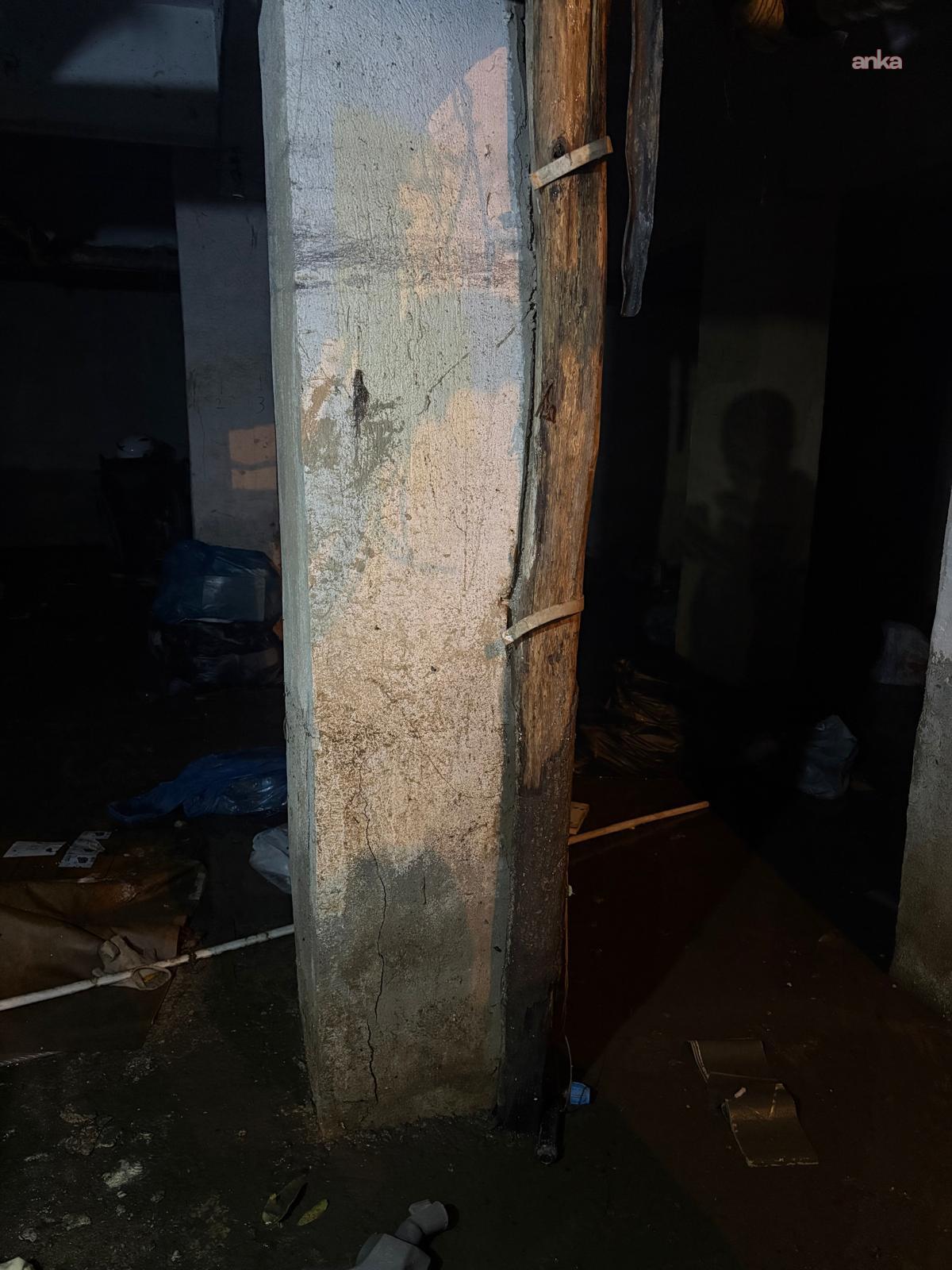 Rissige Säule und Wasseransammlung in einem dunklen Innenraum.