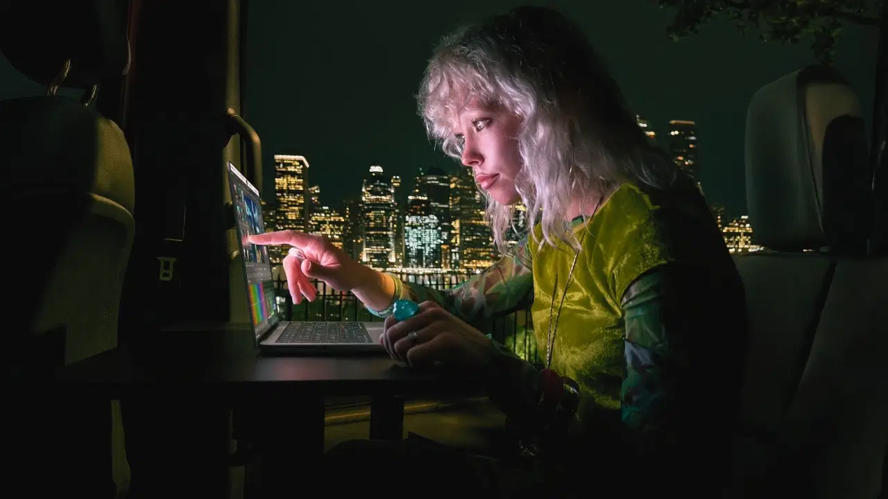 Ein MacBook Pro-Werbebild, das einen Benutzer zeigt, der den Laptop-Bildschirm berührt.