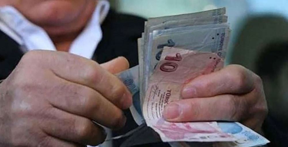 Bir kişinin Türk lirası banknotlarını saydığı yakın plan fotoğraf.