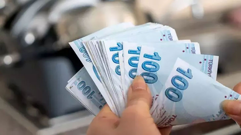Elde tutulan 100 TL banknotlarından oluşan deste.
