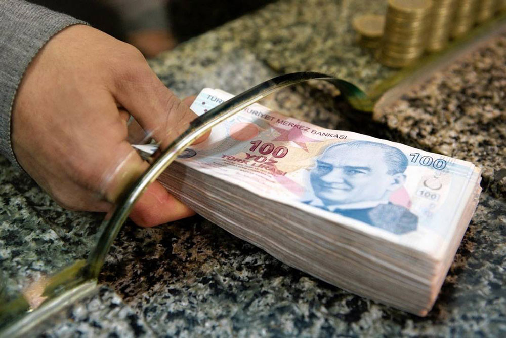 Banka gişesinde deste halinde 100 TL banknotları.