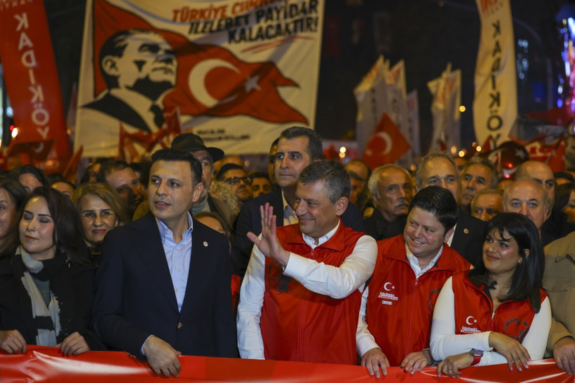 Kalabalık arasında Özgür Özel’in el salladığı, arka planda Türk bayrağı ve Atatürk görselinin yer aldığı yürüyüş fotoğrafı.