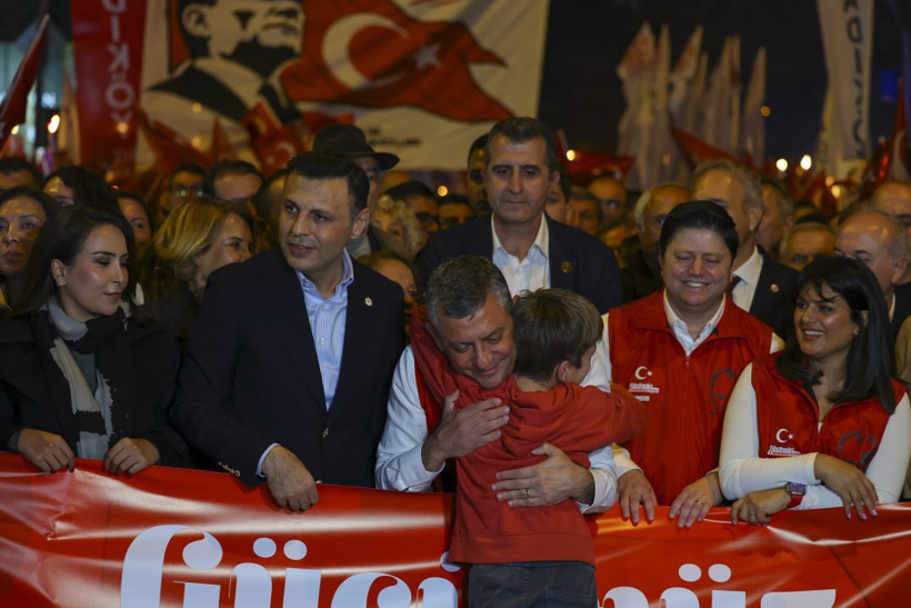 Özgür Özel’in kortej önünde bir çocukla kucaklaştığı Cumhuriyet Yürüyüşü karesi.