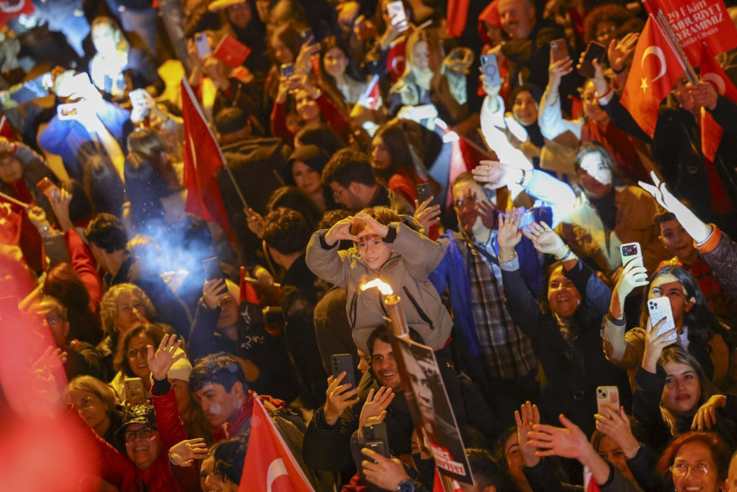 Kalabalıkta Türk bayrakları taşıyan ve cep telefonlarıyla görüntü alan yurttaşlar.