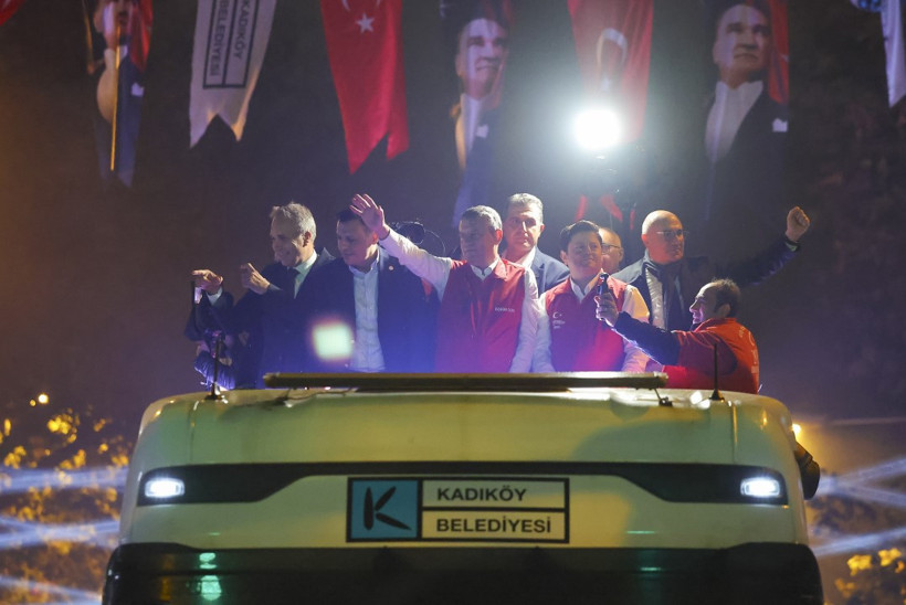Kadıköy Belediyesi aracının üzerinde Özgür Özel ve beraberindeki isimlerin kalabalığı selamladığı gece fotoğrafı.