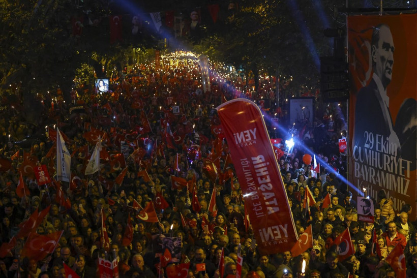 Gece saatlerinde Türk bayrakları ve 29 Ekim afişleriyle dolu geniş bir kalabalık görüntüsü.