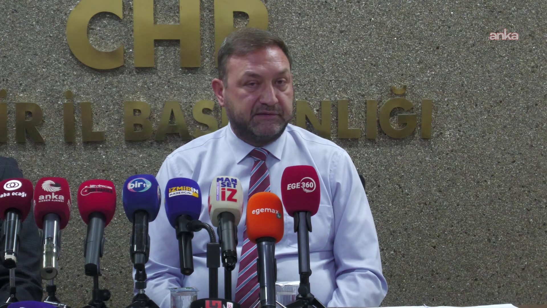 Utku Gümrükçü’nün mikrofonlar önünde konuştuğu yakın plan görüntü.