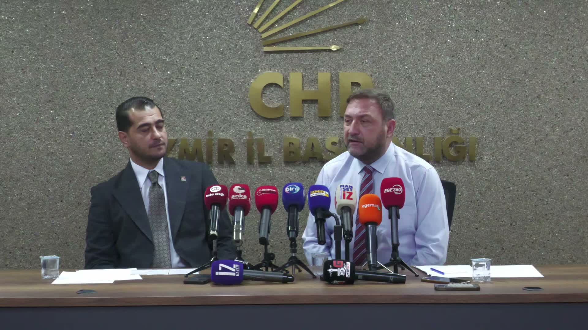 CHP İzmir İl Başkanlığı’nda iki siyasetçinin mikrofonlar önünde yer aldığı toplantı görüntüsü.