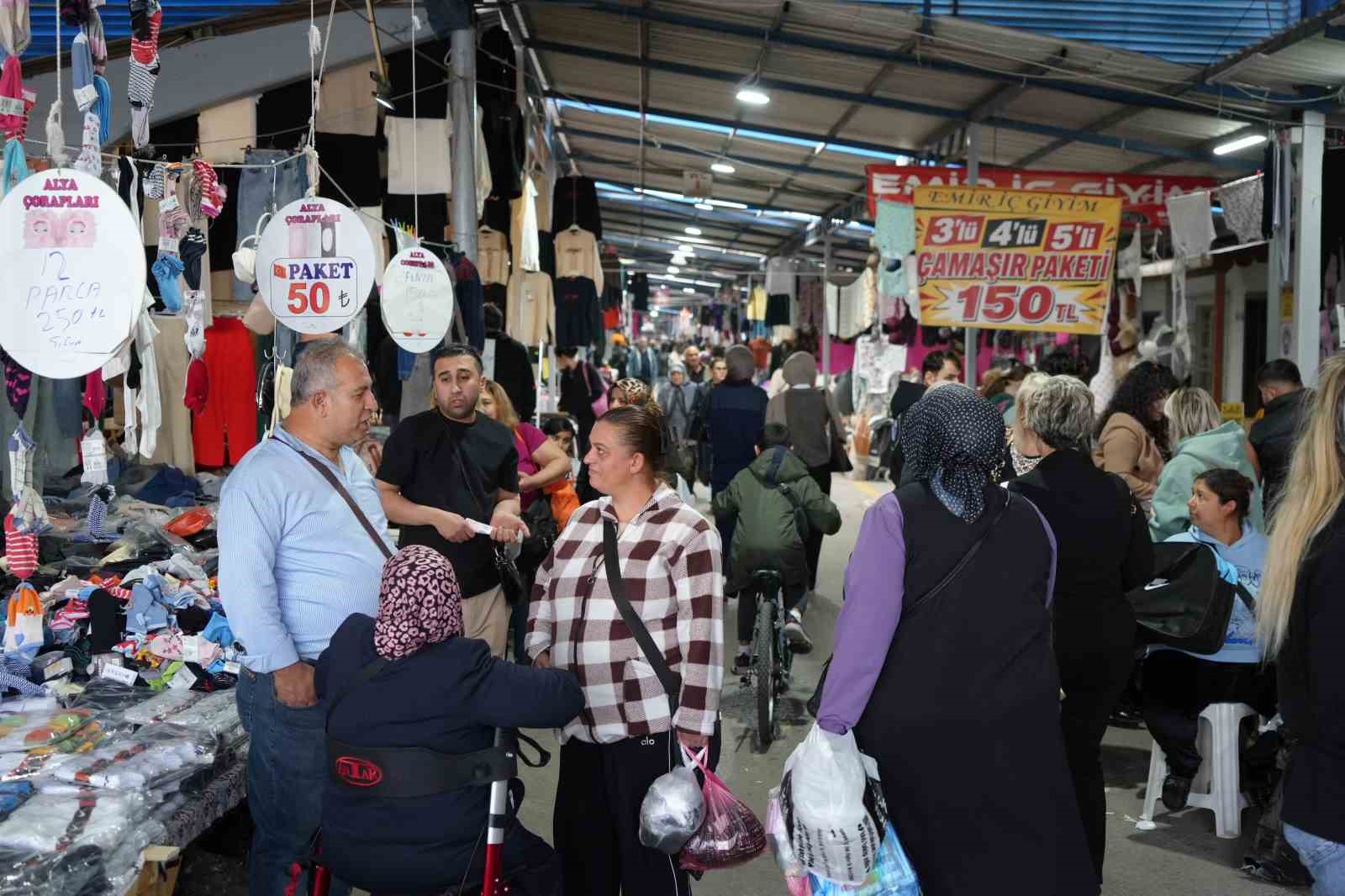 Un corridoio del mercato con banchi di prodotti e folle che fanno acquisti.