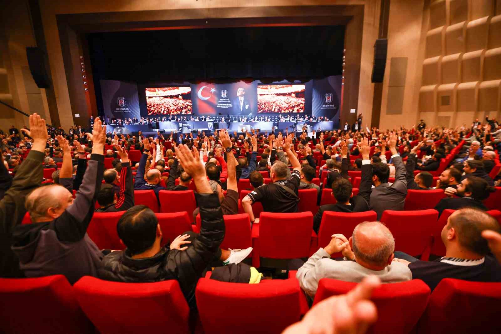 Veduta grandangolare della sala dell'assemblea generale con numerosi membri del Beşiktaş che alzano la mano durante la votazione.