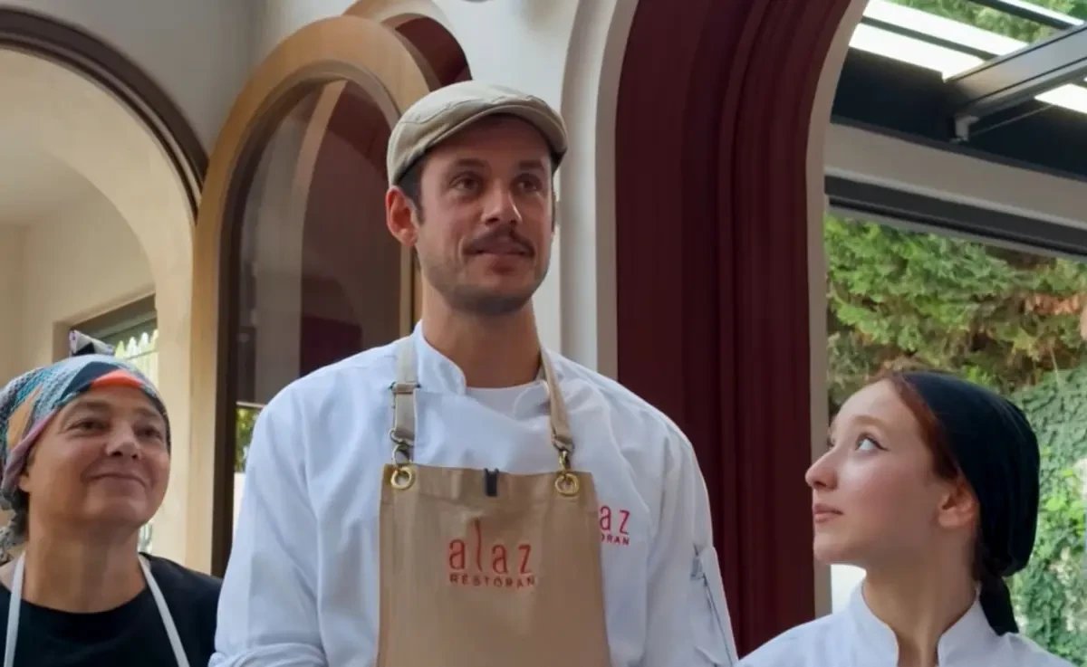 Orkun Işıtmak mutfak çalışanlarıyla birlikte restoran içinde görülüyor.