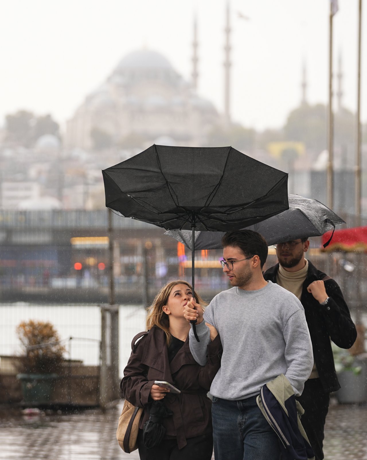 İstanbul’da yağmur altında şemsiye taşıyan yayalar.
