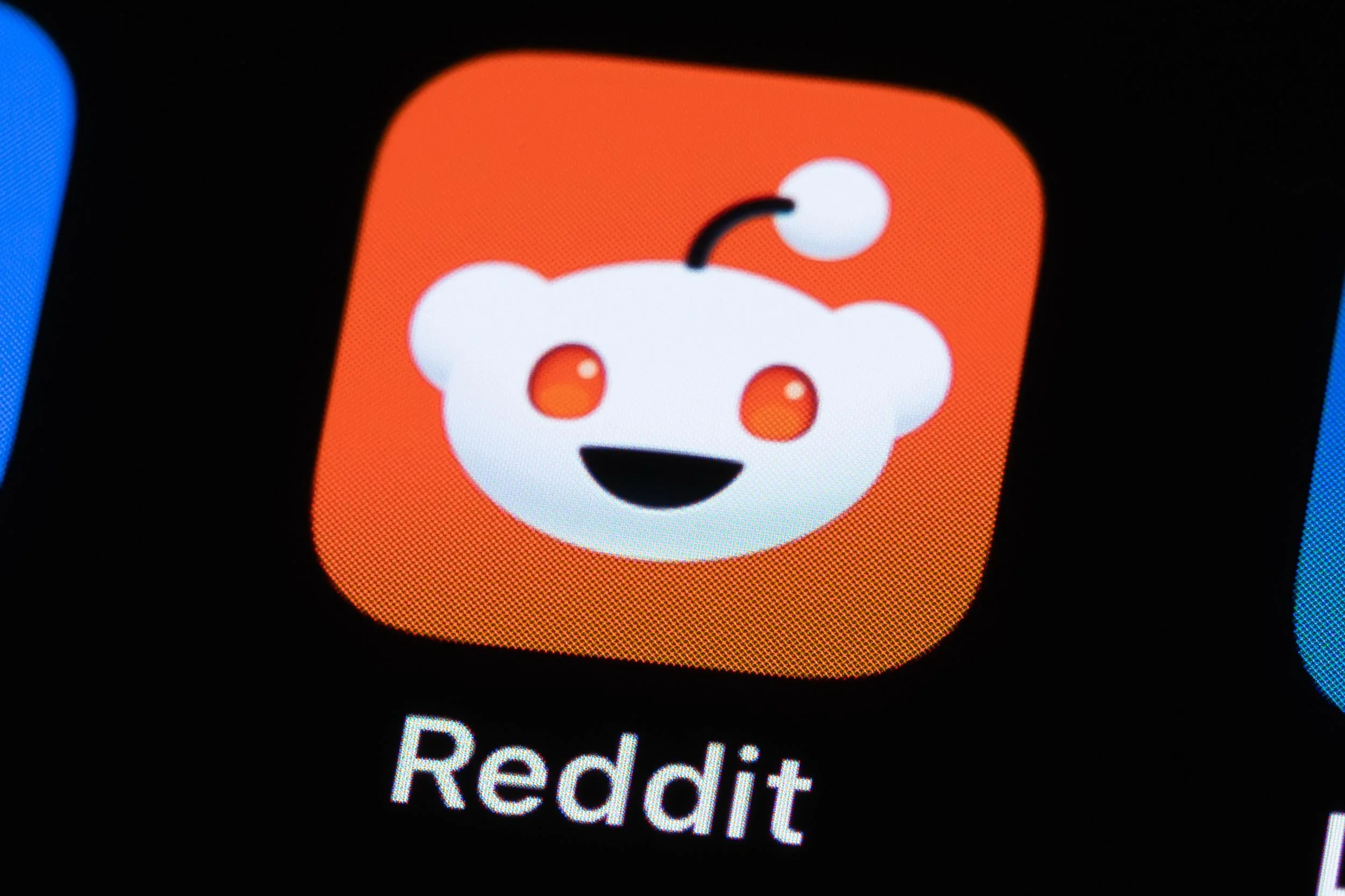 Close-up image showing the Reddit app icon on a smartphone screen.
