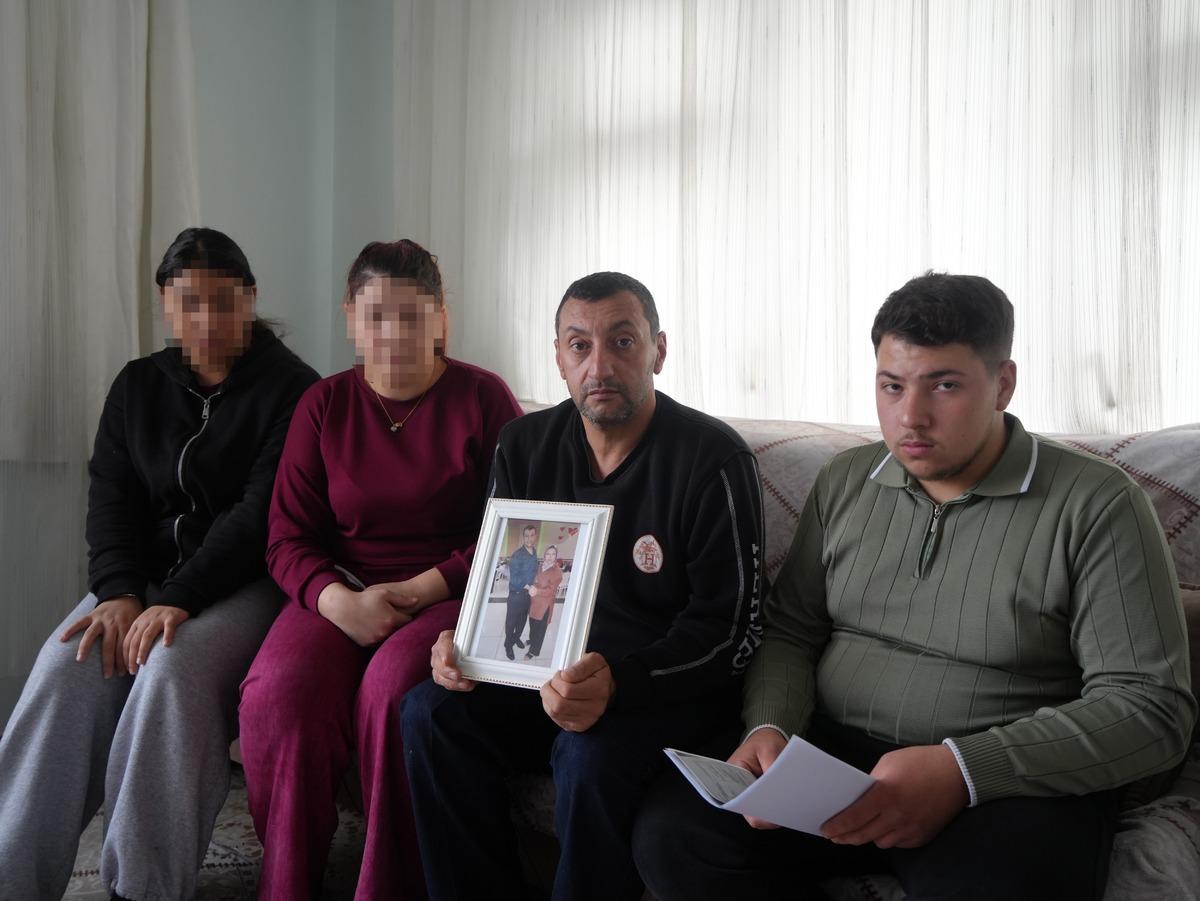 A photograph of Sultan Sever's family taken at home; the faces of her relatives are partially hidden.